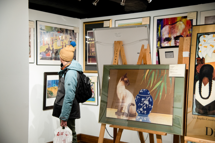 A photo of a patron looking at the art pieces for rent in the MU Art Gallery.