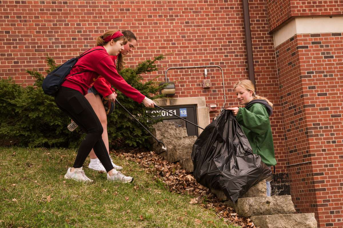 Students working to pick up trash during campus service day