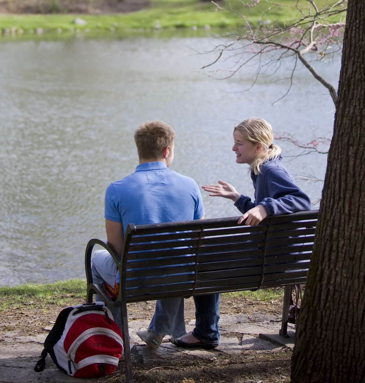 A couple talking on a bench next to Lake Luverne